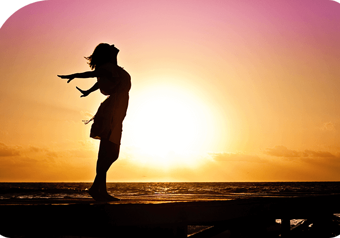 Girl standing on the beach in sun rise